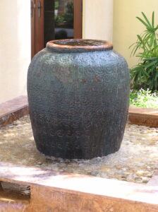 The trickle effect stone outdoor water fountains But Surrounded In a Court Yard Setting.